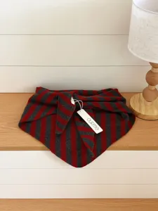 Detailaufnahme eines stilvollen rot-grauen gestreiften Wolltuchs mit weicher Textur.
