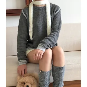 Stylish white fuzzy narrow scarf paired with cozy grey knit sweater and cute leg warmers.