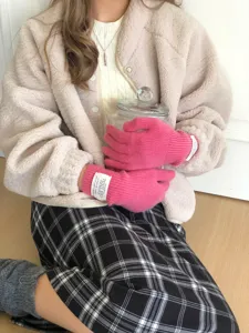 Vue détaillée de gants en laine tricotée rose vif dotés d'une élégante étiquette douce.