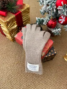 Vue détaillée de gants d'hiver douillets en laine tricotée avec étiquette, décor de fête.