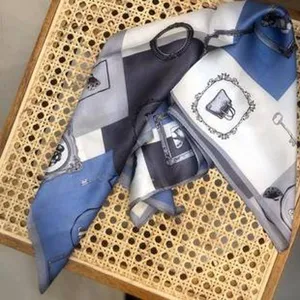 Detaillierte Nahaufnahme von Luxus-Seidenschal mit klassischen Taschen- und Schlüsseldrucken.
