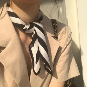 Seidentuch Detailansicht, schwarz-weiß gestreiftes Halstuch, elegantes Styling-Accessoire.