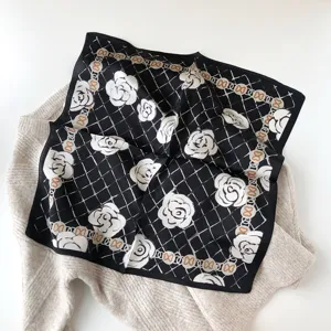 Carré de soie noir avec imprimé de fleurs de camélia blanc et bordure de chaîne élégante.