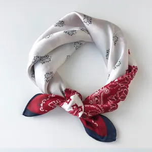 Detailopname van vintage paisley zijden sjaal met een elegant rood en zwart ontwerp.