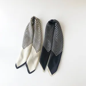 Detailed view of chic black and white striped small silk scarf, elegant minimalist style.