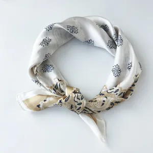 Gedetailleerd uitzicht op klassieke Paisley zijden sjaal, elegant wit accessoire.