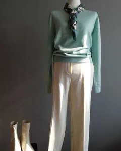 Suéter de punto verde menta y elegante pañuelo con un estampado de estilo ecuestre.