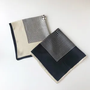 Details of the geometric striped silk-feel square scarf, elegant black and beige design.