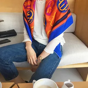 Luxury silk square scarf with vibrant orange and blue horse bit pattern for elegant women.