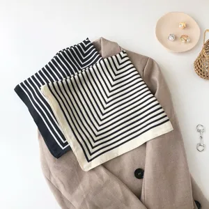 Detailed view of elegant geometric striped silk square scarf styled on a chic beige blazer.