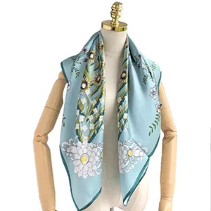 Silk square scarf detail view showing elegant floral print and delicate hand-rolled edge.