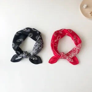 Detail view of chic silk feel small square scarf with classic paisley print in dual colors.