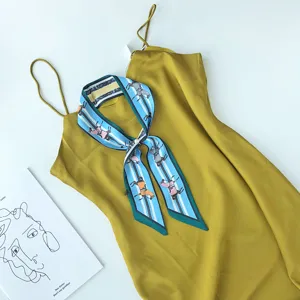 Elegant zomer zijden sjaal en gele slipdress set, smal twilly lint accessoire detailansicht.