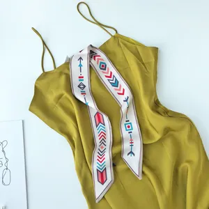 Gedetailleerd overzicht van de elegante satijnen jurk en bedrukte smalle zijden sjaal voor dames.