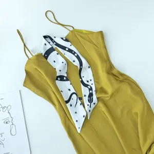 Elegante gele slipdress gecombineerd met een chique zwart-witte sterren slanke sjaal.