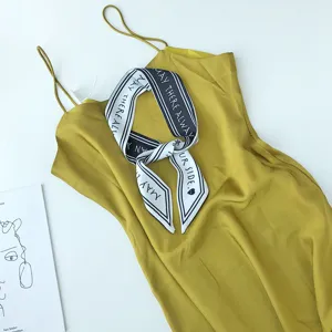 Elegante dames zomer gele zijde satijn slip jurk met modieuze bedrukte lange sjaal accessoire.