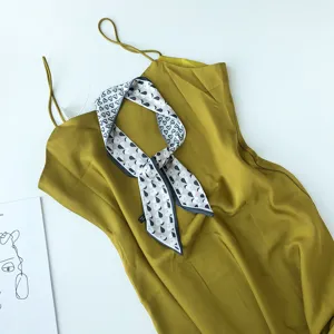 Stijlvolle smalle zomersjaal gecombineerd met mosterdgeele jurk, prachtig mode-accessoire.