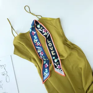 Gedetailleerd overzicht van een elegante gele slipdress gecombineerd met een bloemige sjaal.