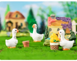 Gros plan de charmants ornements miniatures en résine de canard pour décoration de bureau micro.