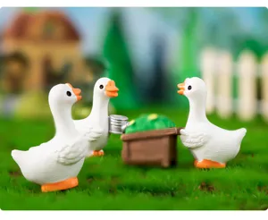 Figurines de mini canards en résine mignons dans une scène de microlaysage pour bureau.