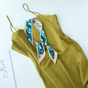 Gedetailleerd overzicht van een elegante olijfgroene slipjurk met gekleurde zijden sjaal.