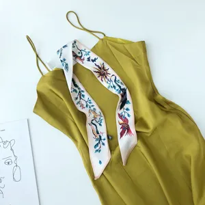 Olijfgroene slipjurk gecombineerd met een elegante bedrukte smalle zijden sjaal detail.