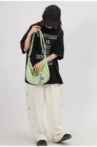 Λεπτομέρεια πράσινης καρό slouchy hobo τσάντας ώμου, casual καμβάς χιαστί τσάντα σκηνή.