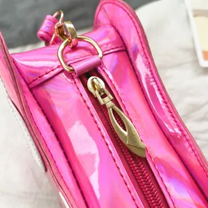 Detailaufnahme der pinken Laser PU Leder Umhängetasche mit goldenem Reißverschluss.
