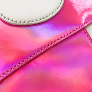 Detaillierte Nahaufnahme der glänzenden holografischen rosa PU-Leder-Taschentextur und Nähte.