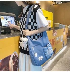 Sac bandoulière en toile style collège coréen avec poche à carreaux mignonne et pendentif ours.