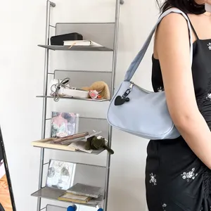 Λεπτομερής λήψη κοντινού πλάνου της κομψής γαλάζιας τσάντας ώμου με καρδιά μενταγιόν.