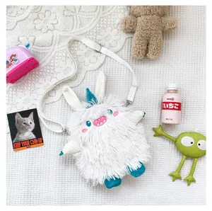Detailansicht der kuscheligen weißen Plüsch-Monstertasche mit weichem Material und lustiger Stickerei.
