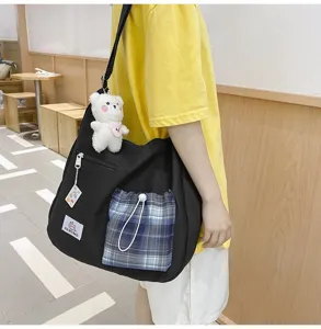 Sac bandoulière en toile style coréen avec poche à carreaux bleus et joli pendentif ours en peluche.