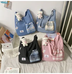 Sac bandoulière en toile avec poche avant à cordon quadrillé et charmant pendentif d'ours.