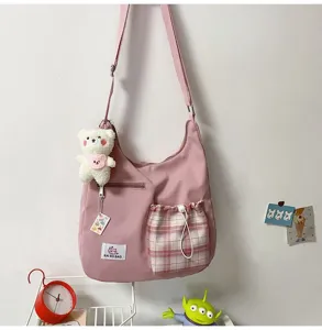 Sac bandoulière en toile rose avec poche à carreaux et charmant pendentif ours pour femmes.
