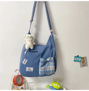 Sac bandoulière en toile coréen avec pendentif ours mignon et poche à carreaux chic.
