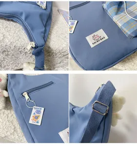 Gros plan des détails du sac bandoulière bleu montrant la fermeture et l'étiquette.