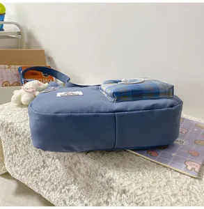 Sac bandoulière en toile bleue style coréen avec poche avant à carreaux et pendentif peluche.