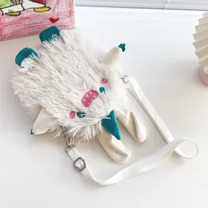 Süße weiße Plüsch Monster Umhängetasche mit besticktem Gesicht und blauem Horn Detail.