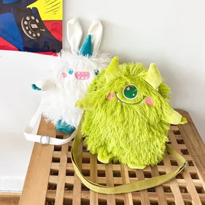 Detailaufnahme süßer Plüsch Monster Umhängetaschen mit weicher flauschiger Textur und Stickerei.