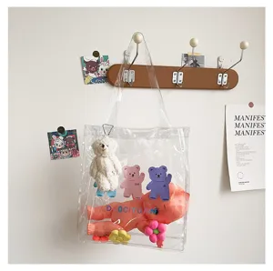 Detailansicht der transparenten PVC-Umhängetasche mit niedlichen Cartoon-Bären und Plüschtier.