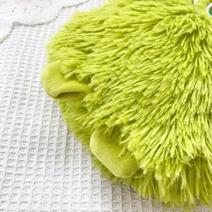 Grüne flauschige Plüsch Monster Tasche Detailaufnahme mit weicher zotteliger Textur und Füßen.
