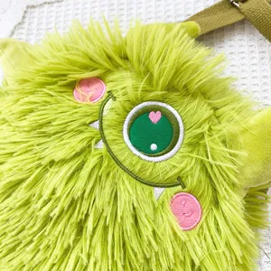 Süße flauschige grüne Monster Umhängetasche Detailaufnahme, weiches Plüschmaterial mit Stickerei.