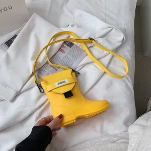 Vue détaillée du sac bandoulière créatif en forme de botte jaune au design unique et compact.