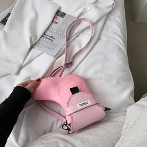 Vue détaillée du sac bandoulière rose en forme de botte, design de chaussures unique avec sangle.