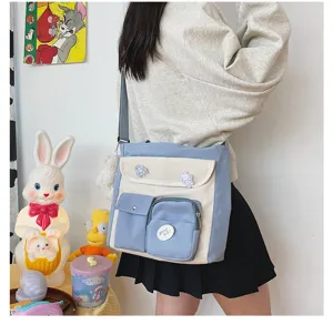 Detailed view of the canvas crossbody messenger bag in blue and beige color block style.