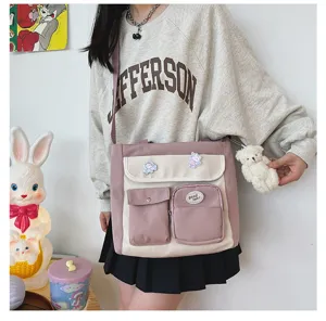 Detailed view of canvas crossbody bag with multi pockets, cute bear pendant and badges.