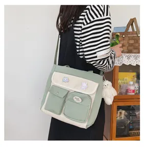 Detail view of a vintage canvas crossbody bag with multi-pockets and cute bear pendant.