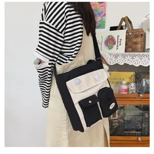 Detailed view of casual canvas crossbody bag featuring multi pockets and cute pins.