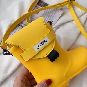 Vue détaillée du sac bandoulière tendance en forme de botte jaune avec sangle et boucle.